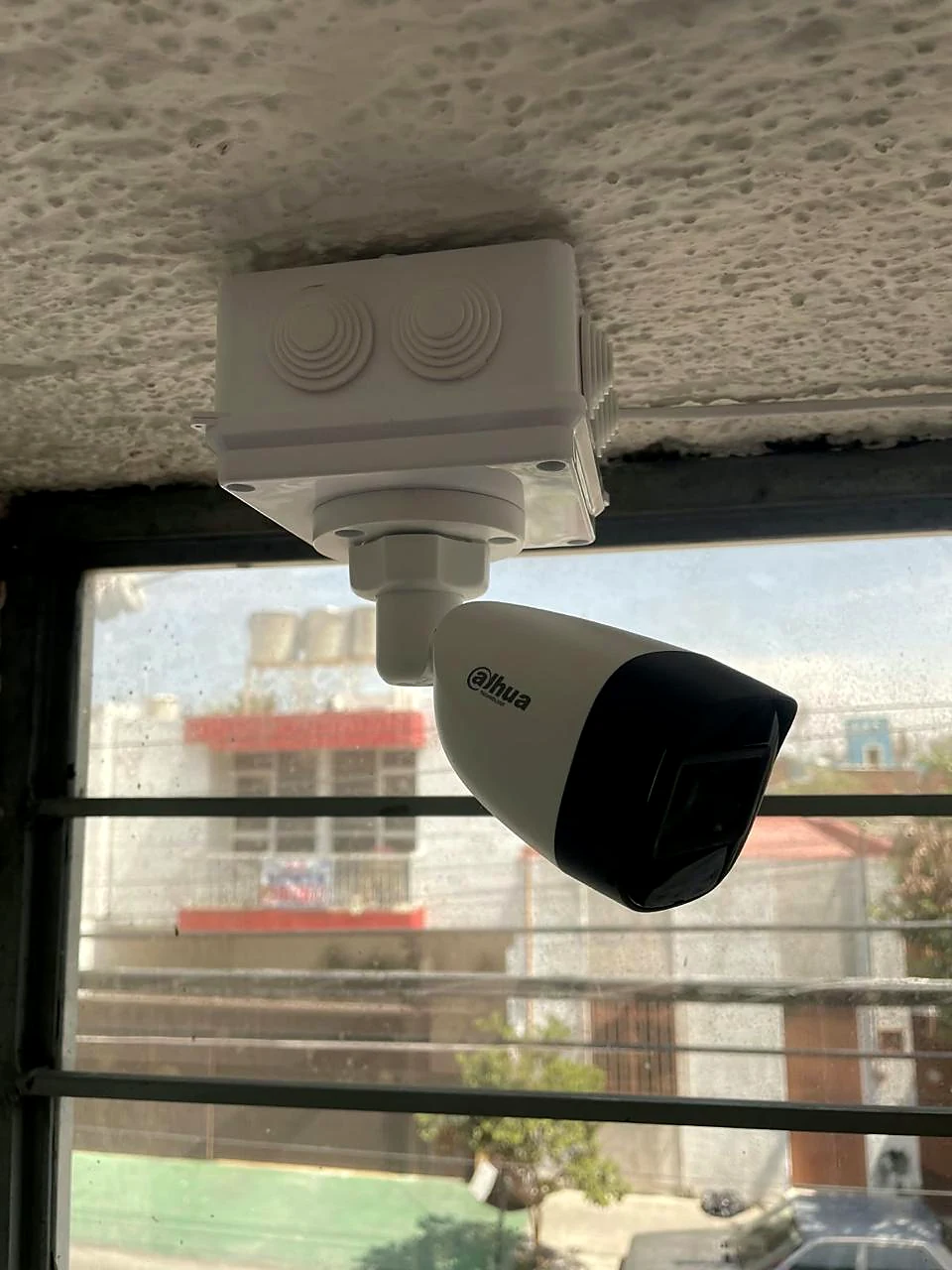 Cámara bala Dahua con caja sellada apuntando a la calle desde un negocio