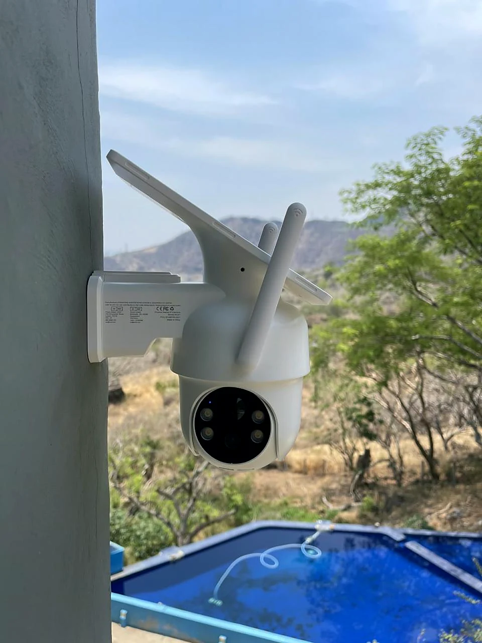 Cámara Wi-Fi con panel solar vigilando el terreno y la alberca de un rancho